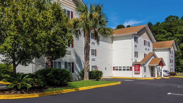 A two-story hotel with a red roof, a red awning, and a red sign on the front. - Red Roof Inn Darien - I-95/ North Brunswick (Darien)