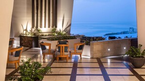 A terrace with seating and a view of the ocean.