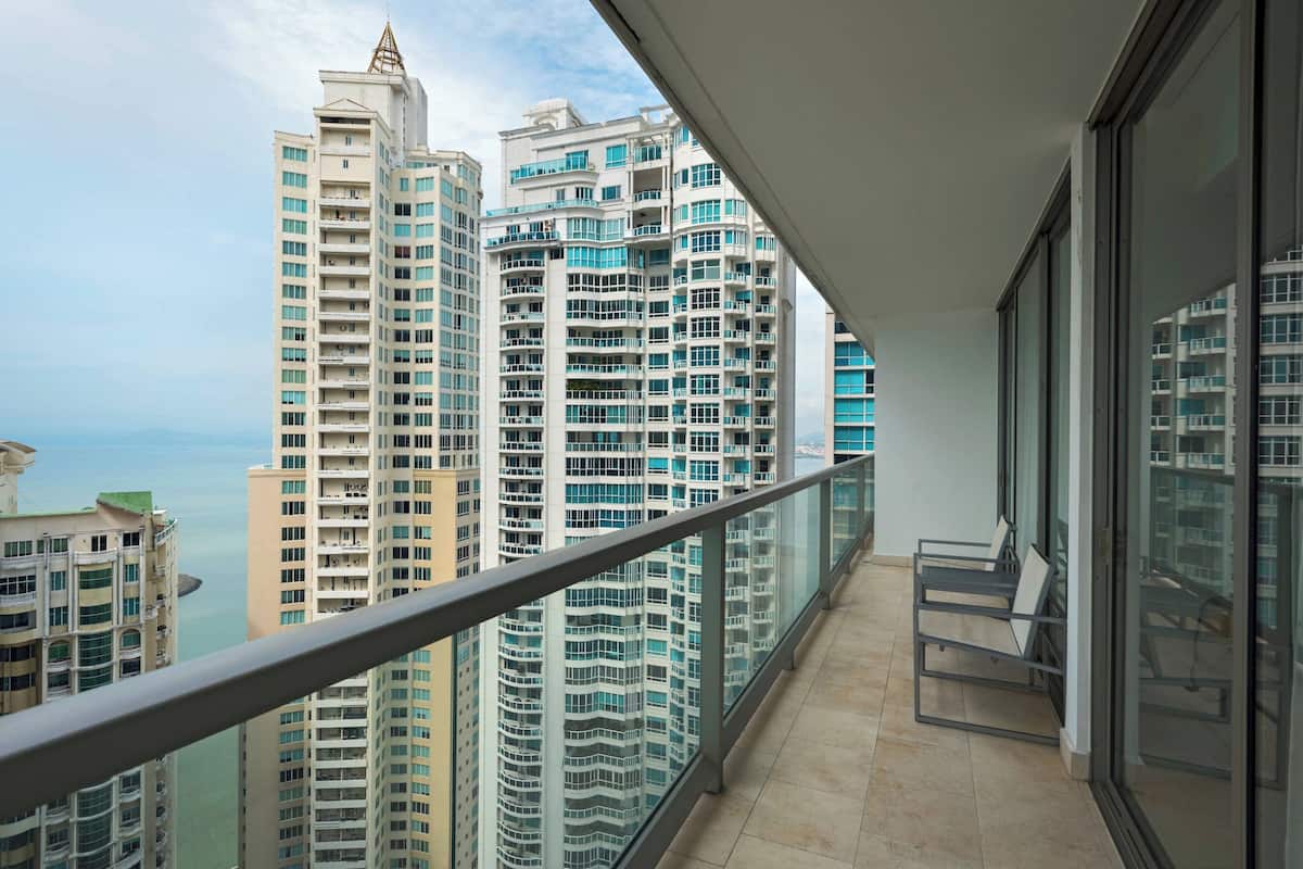 Un balcón con vista a edificios altos y una masa de agua.