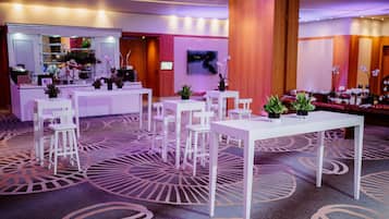 A hotel lobby with white furniture, a reception desk, and a large mirror.