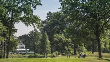 Enjoy a peaceful golfing experience amidst lush greenery and mature trees.