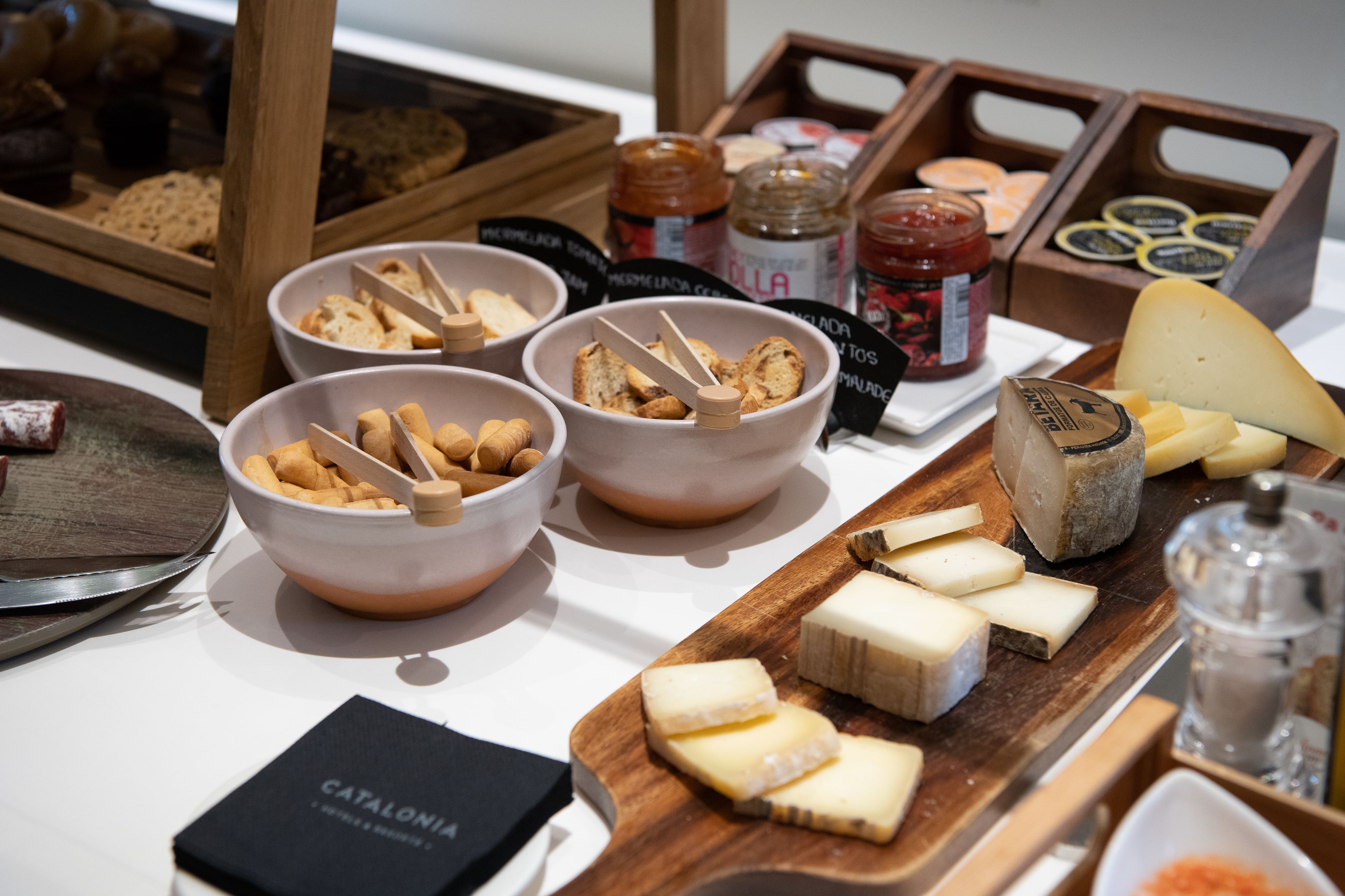 Una exhibición de quesos y pan con distintos tipos de queso y galletas.