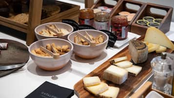 Una exhibición de quesos y pan con distintos tipos de queso y galletas.