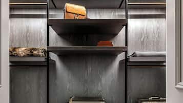 A storage unit with multiple shelves and drawers, a suitcase, and a pair of slippers.