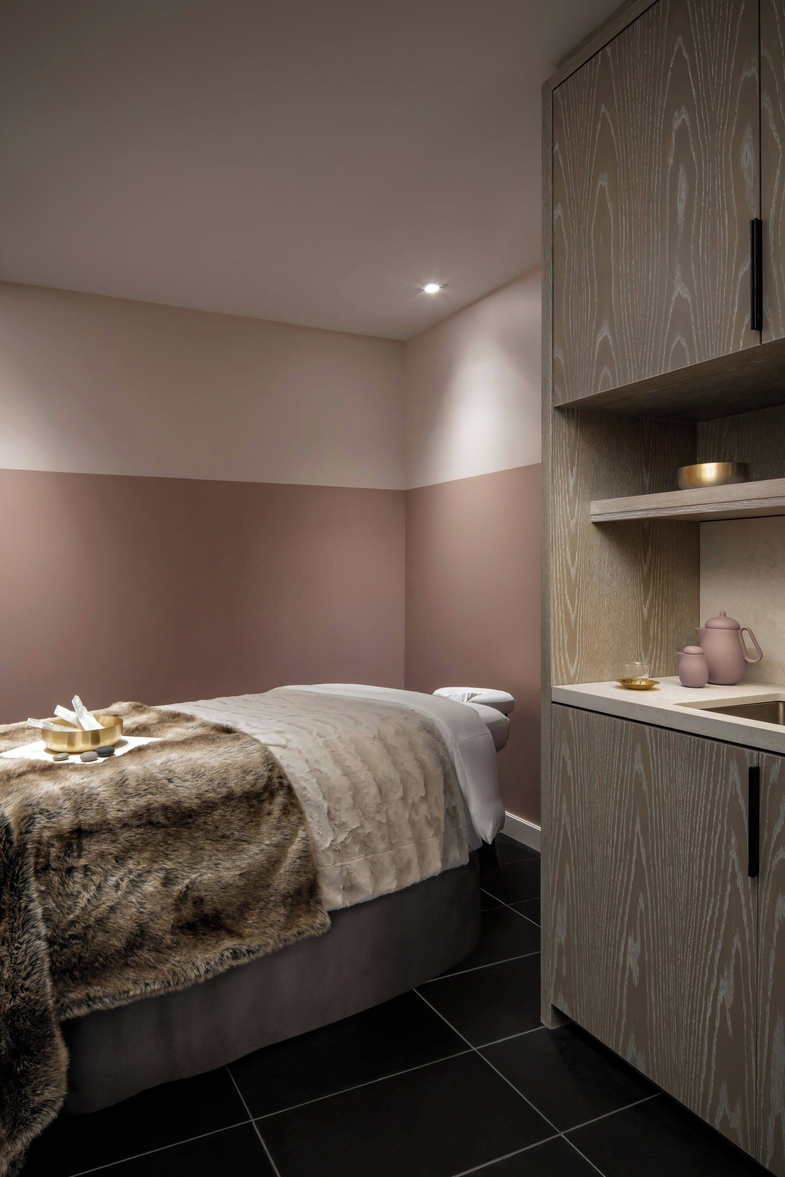 A bedroom with a bed, a bedside table, a nightstand, and a wardrobe.
