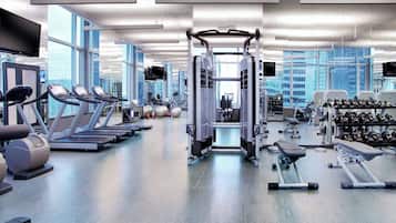 A modern gym with treadmills, weight machines, and dumbbells.