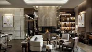 A modern living room with a fireplace, comfortable seating, and a decorative wall.