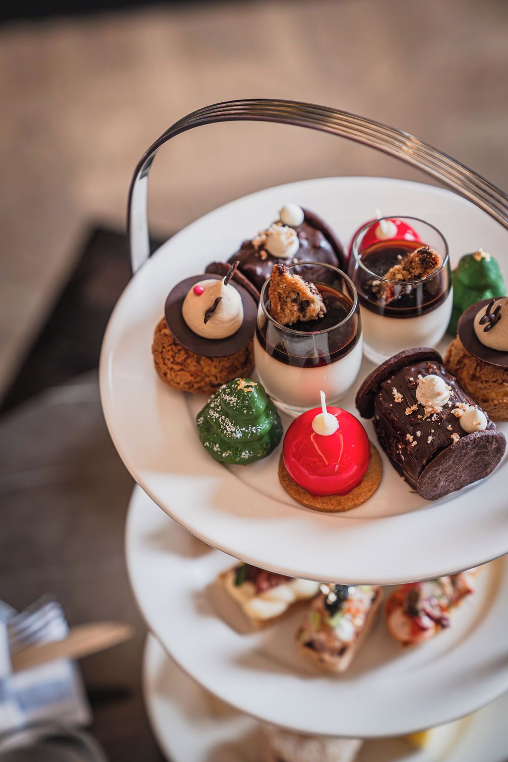 Un plato de postres de varios niveles con diferentes dulces y una vela.
