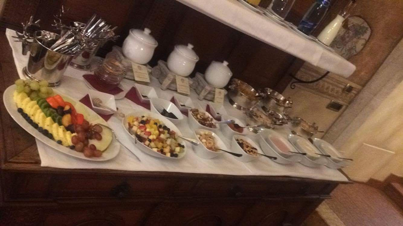 A buffet table with various food items and utensils.