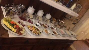 A buffet table with various food items and utensils.