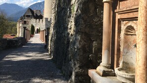 Un edificio histórico de piedra con un patio, columnas y una torre.