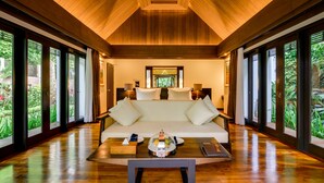 A spacious room with a large bed, a wooden floor, and large windows offering a view of greenery. - The Samaya Ubud (Ubud)
