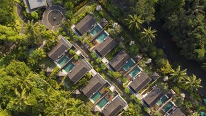 An aerial view of a resort with multiple bungalow-style accommodations, each with a private pool, surrounded by lush greenery and palm trees. - The Samaya Ubud (Ubud)