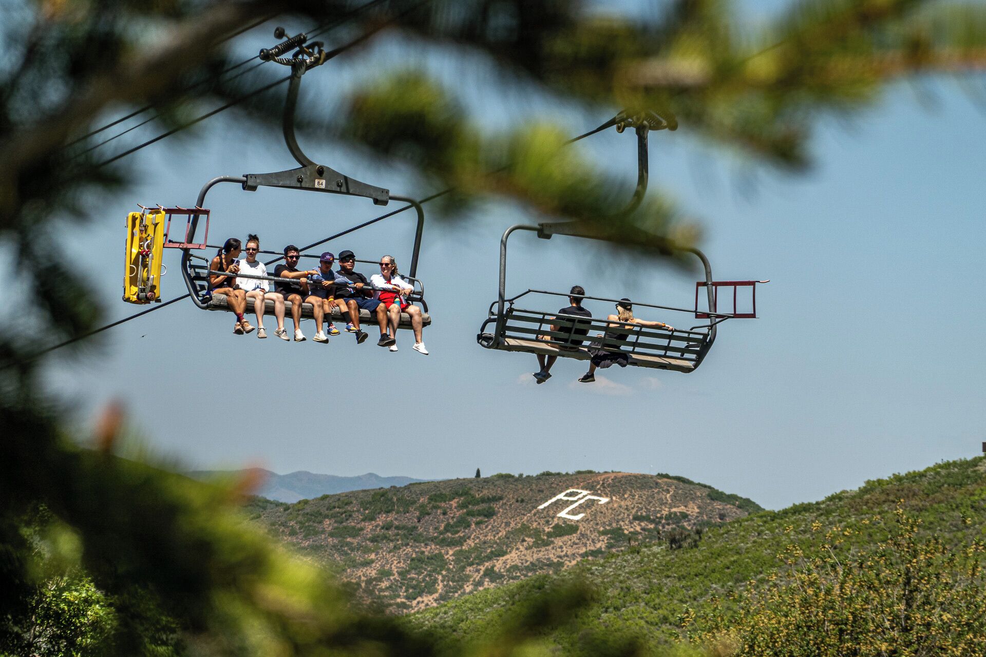 Un teleférico con pasajeros, suspendido sobre un paisaje montañoso.