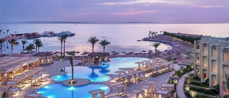 Una piscina al aire libre, sombrillas, tumbonas