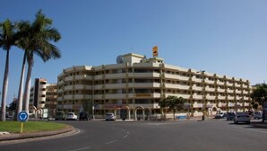 Um hotel de vários andares com fachada curva, diversas varandas e uma entrada central.