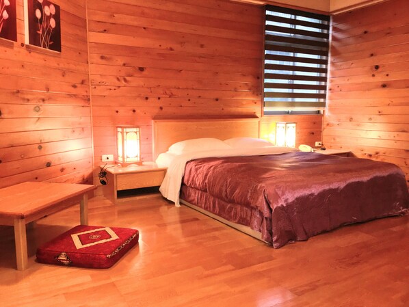 A wooden cabin bedroom with a bed, bedside tables, a bench, and a window with blinds. - Eastern Beauty Hotel (Taipei)
