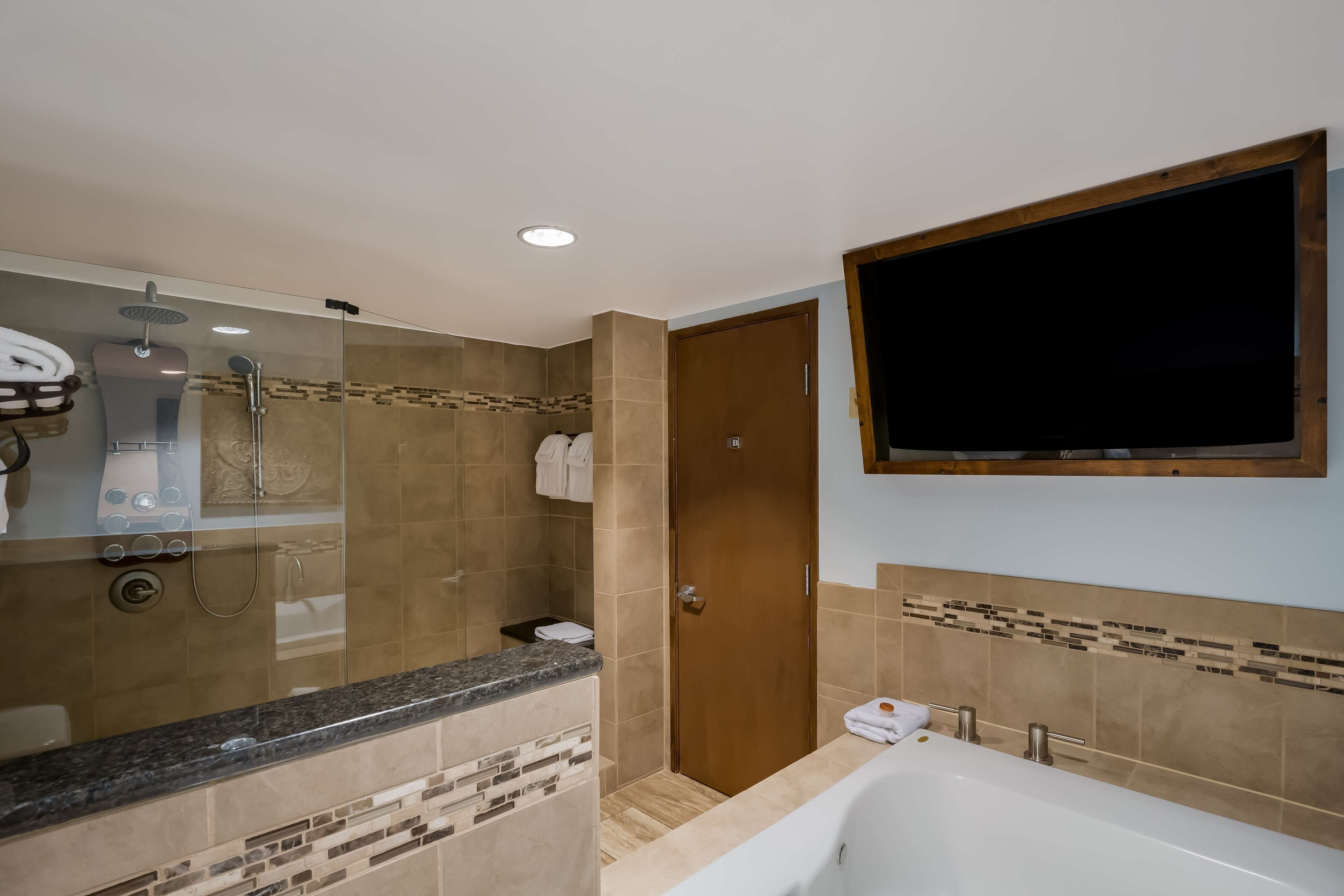 A modern bathroom with a shower, toilet, and bathtub.