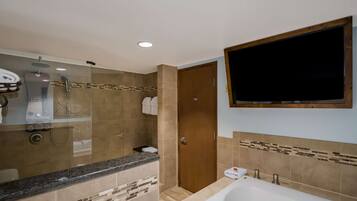 A modern bathroom with a shower, toilet, and bathtub.