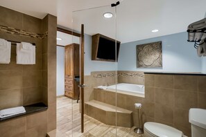 Un baño moderno con ducha envuelta en vidrio, una bañera y un inodoro.