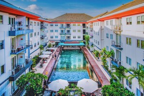 Un hôtel doté d’une piscine centrale, de nombreux balcons et d’espaces extérieurs aménagés pour se détendre.