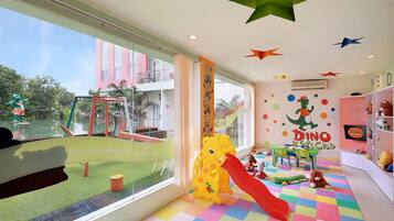 Children can play and learn in this vibrant space with a play mat, slide, and dinosaur-themed playset.