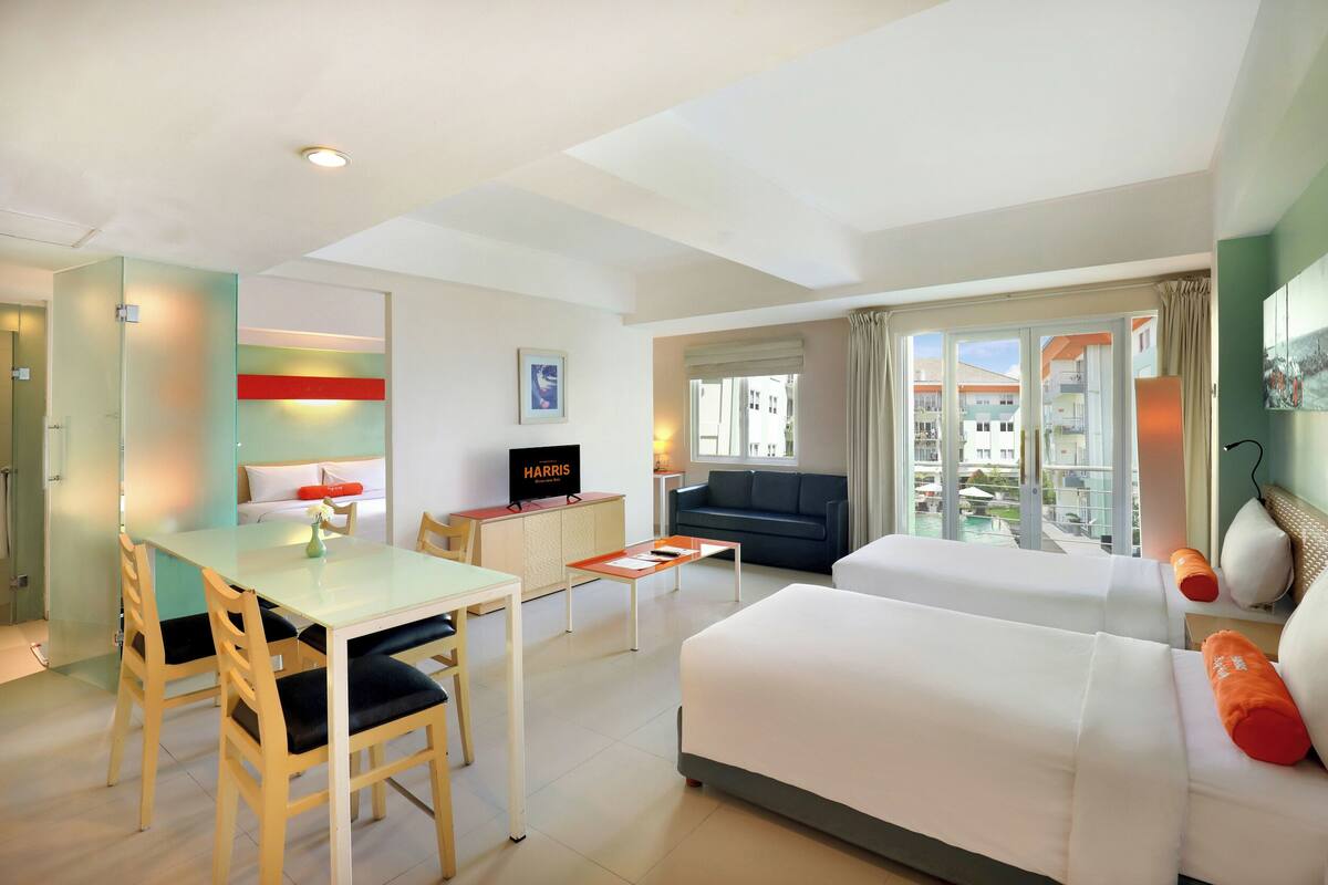 Ein modernes Hotelzimmer mit Essbereich, einer Couch und Blick auf die Stadt.