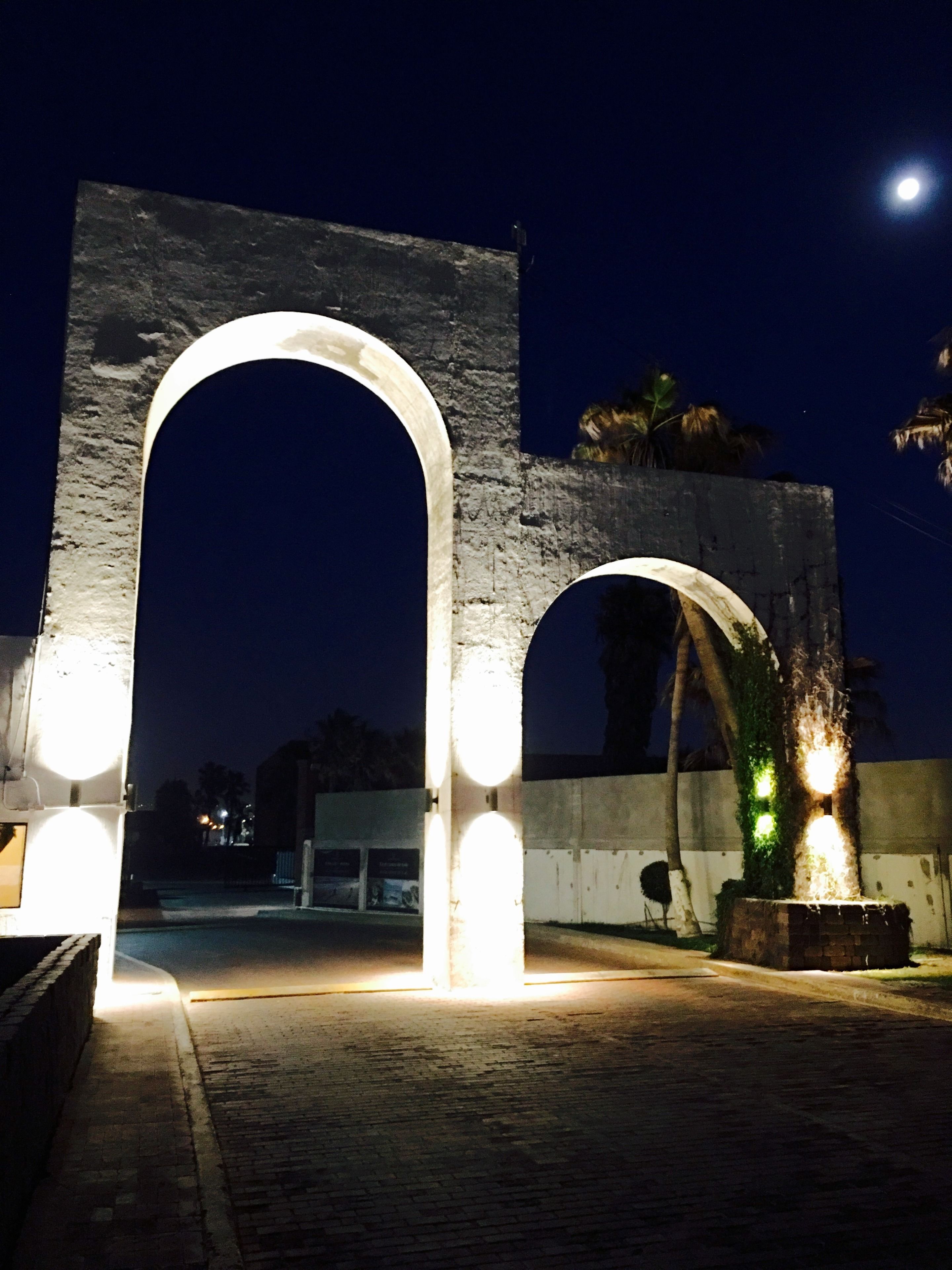 Una gran estructura en forma de arco iluminada durante la noche.