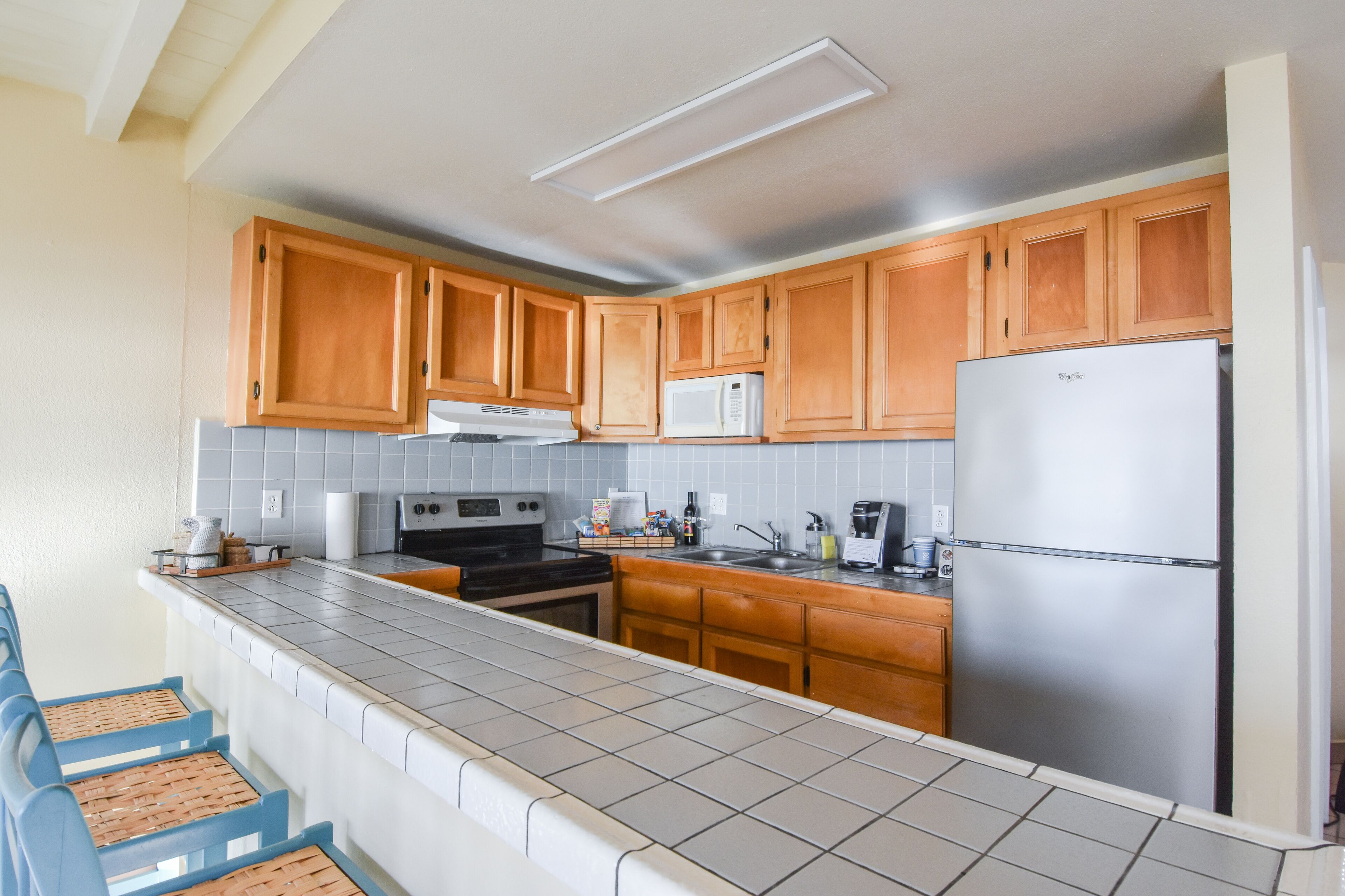 Une cuisine avec des meubles en bois, un réfrigérateur en acier inoxydable, un four à micro-ondes et une cuisinière.