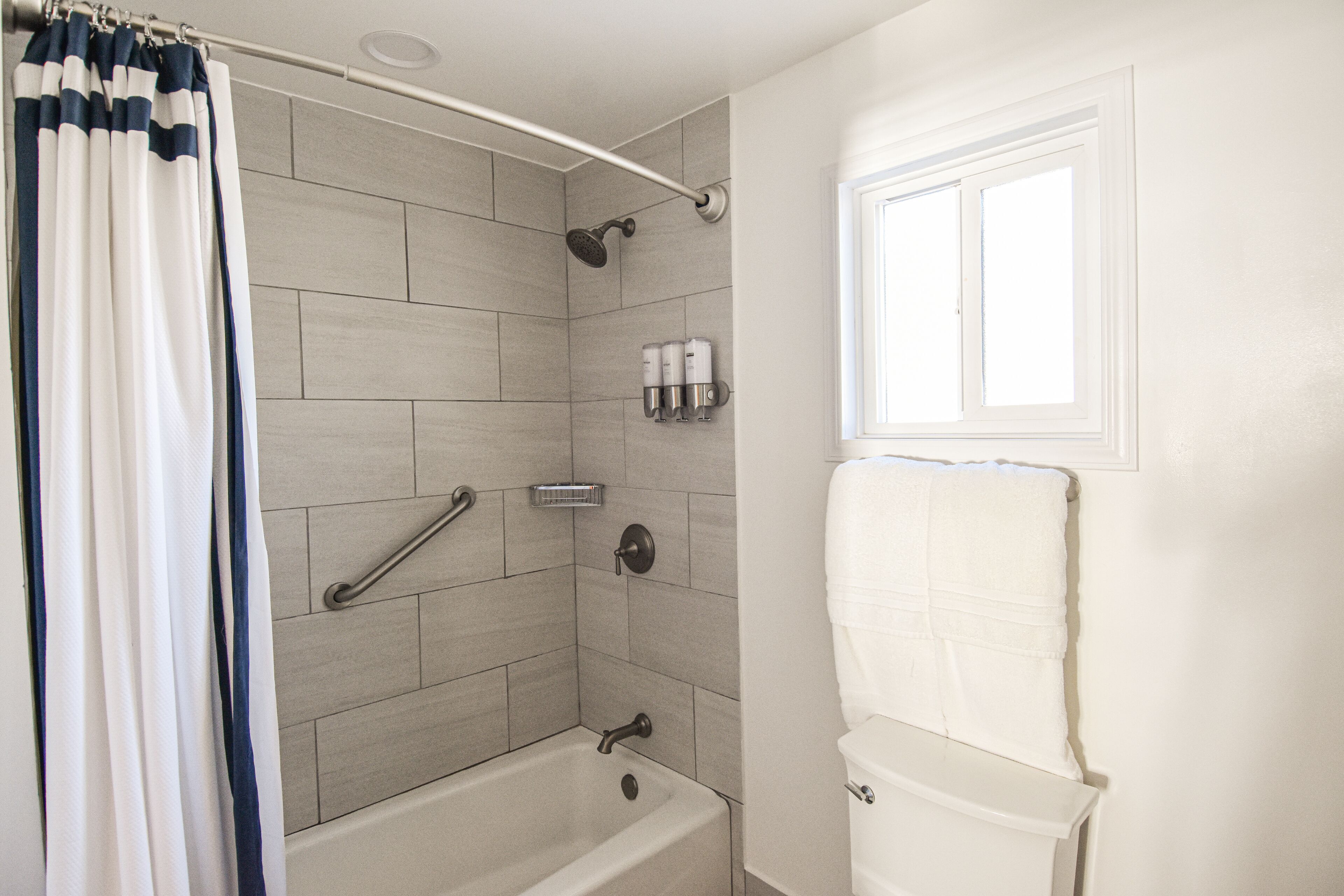 A bathroom with a bathtub, shower, and toilet.