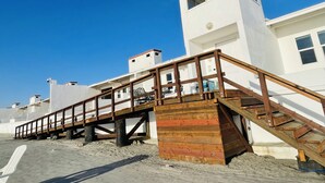 Un edificio costero con una escalera de madera que conduce a una torre blanca.