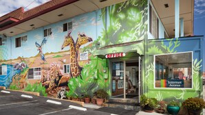 A building with a mural of animals and a sign indicating an office and internet access. - Aqua Breeze Inn (Santa Cruz)