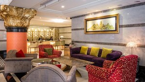 A lobby with a grand column, a reception desk, and a seating area with patterned sofas. - Royal Palace Hotel (Taipei)