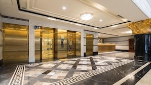A lobby with a marble floor, elevators, and a reception desk. - Royal Palace Hotel (Taipei)