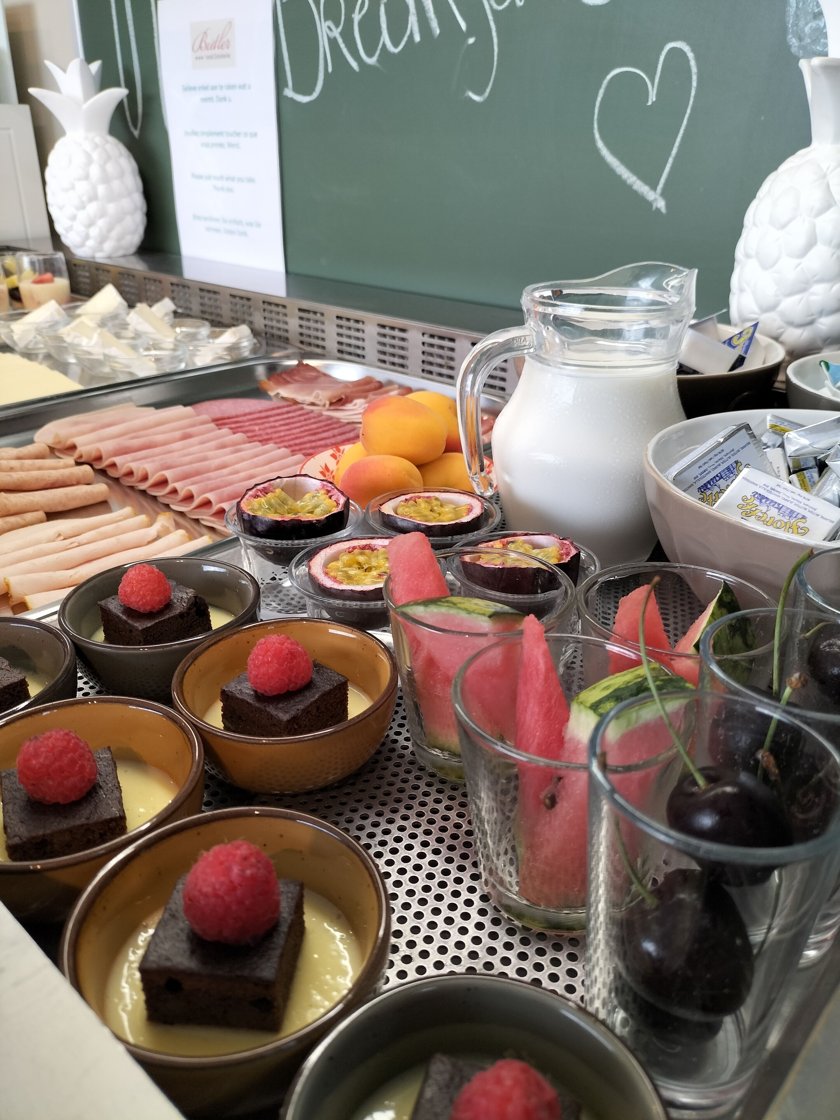 Um buffet de sobremesas com diversos doces e frutas.