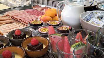 Um buffet de sobremesas com diversos doces e frutas.