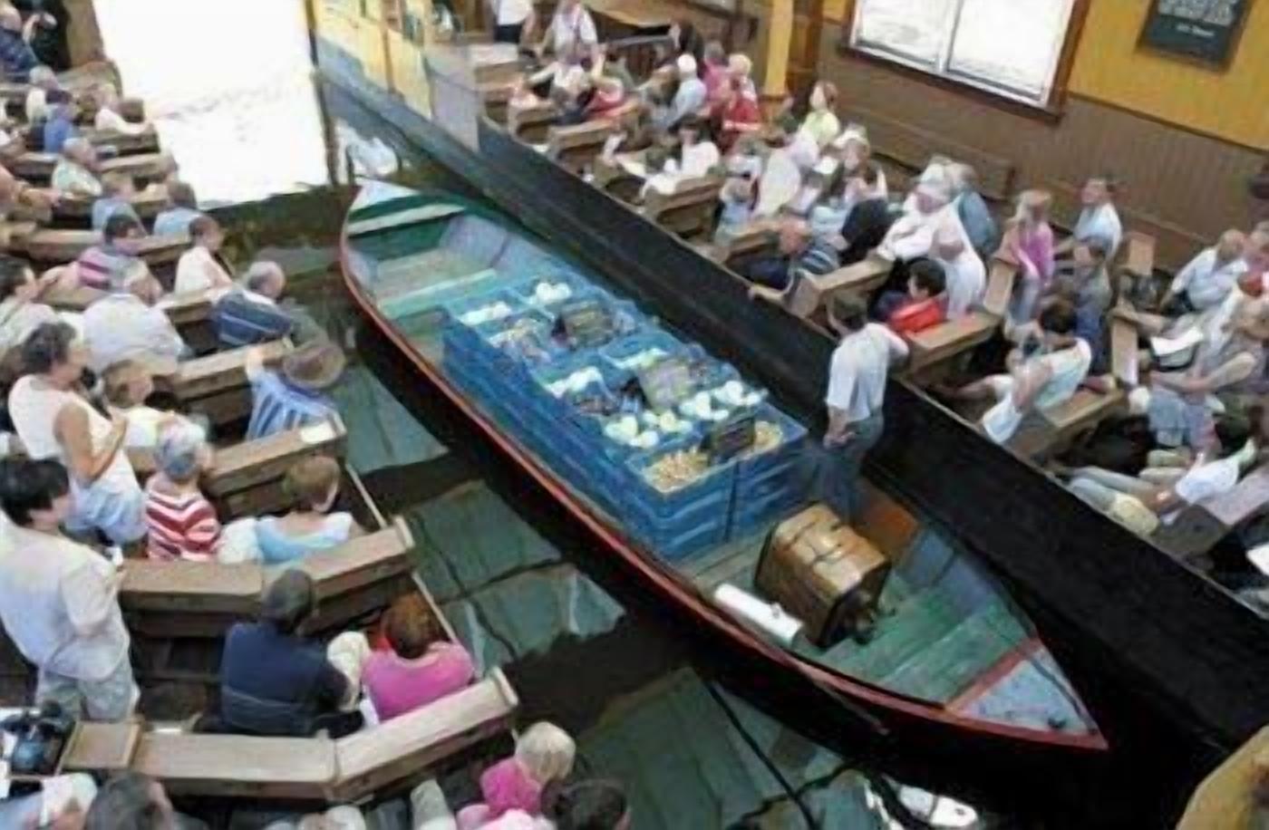 A boat-shaped room with seating arranged around it, likely used for dining or events.
