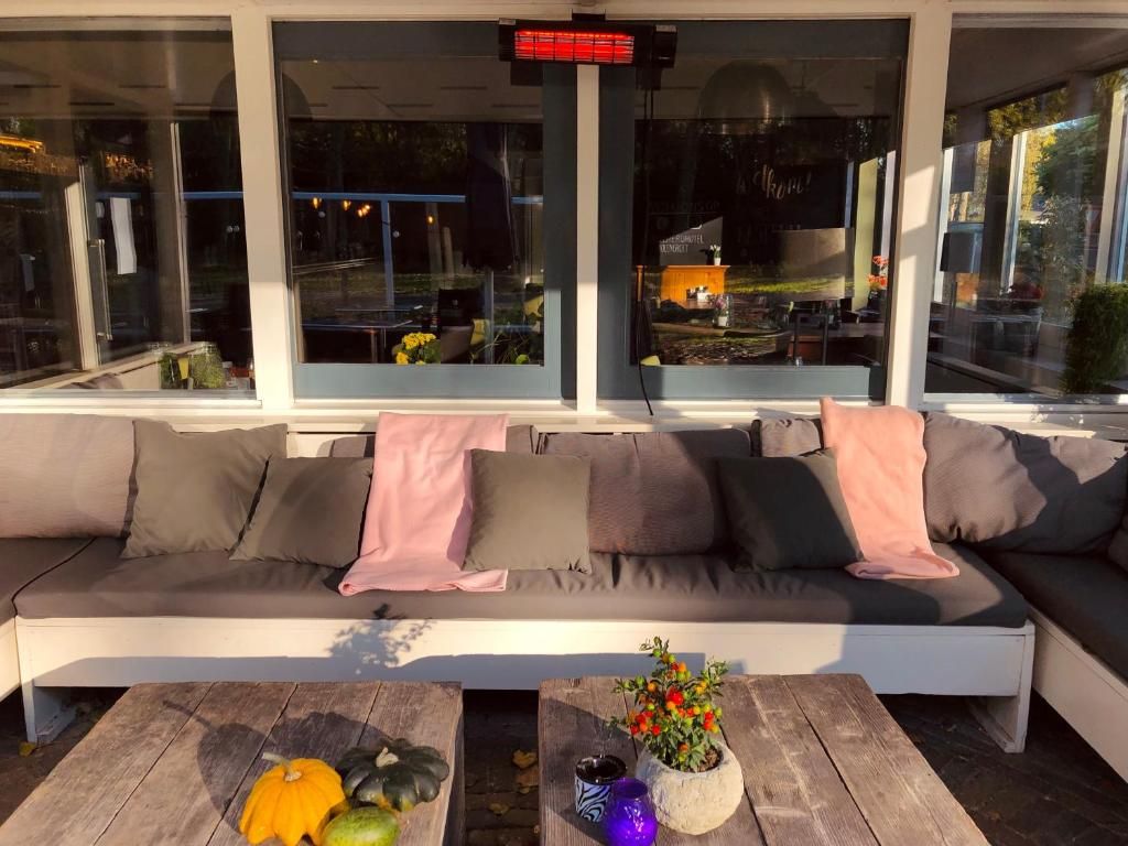 Un área de estar al aire libre, moderna, con un sofá y una mesa de madera.