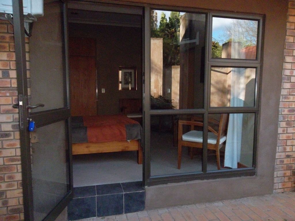 A room with a bed, a chair, and a window.