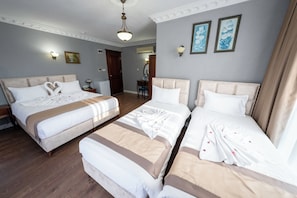 A hotel room with two beds, a desk, a chair, a wardrobe, and a bathroom door. - Basileus Hotel (Istanbul)