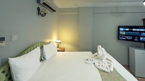 Ein Hotelzimmer mit Bett, Fernseher und Minibar.