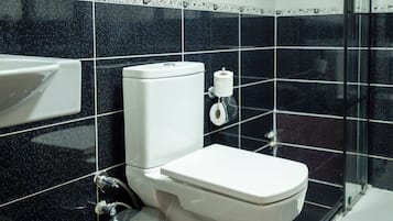 A bathroom with a toilet, sink, and shower.