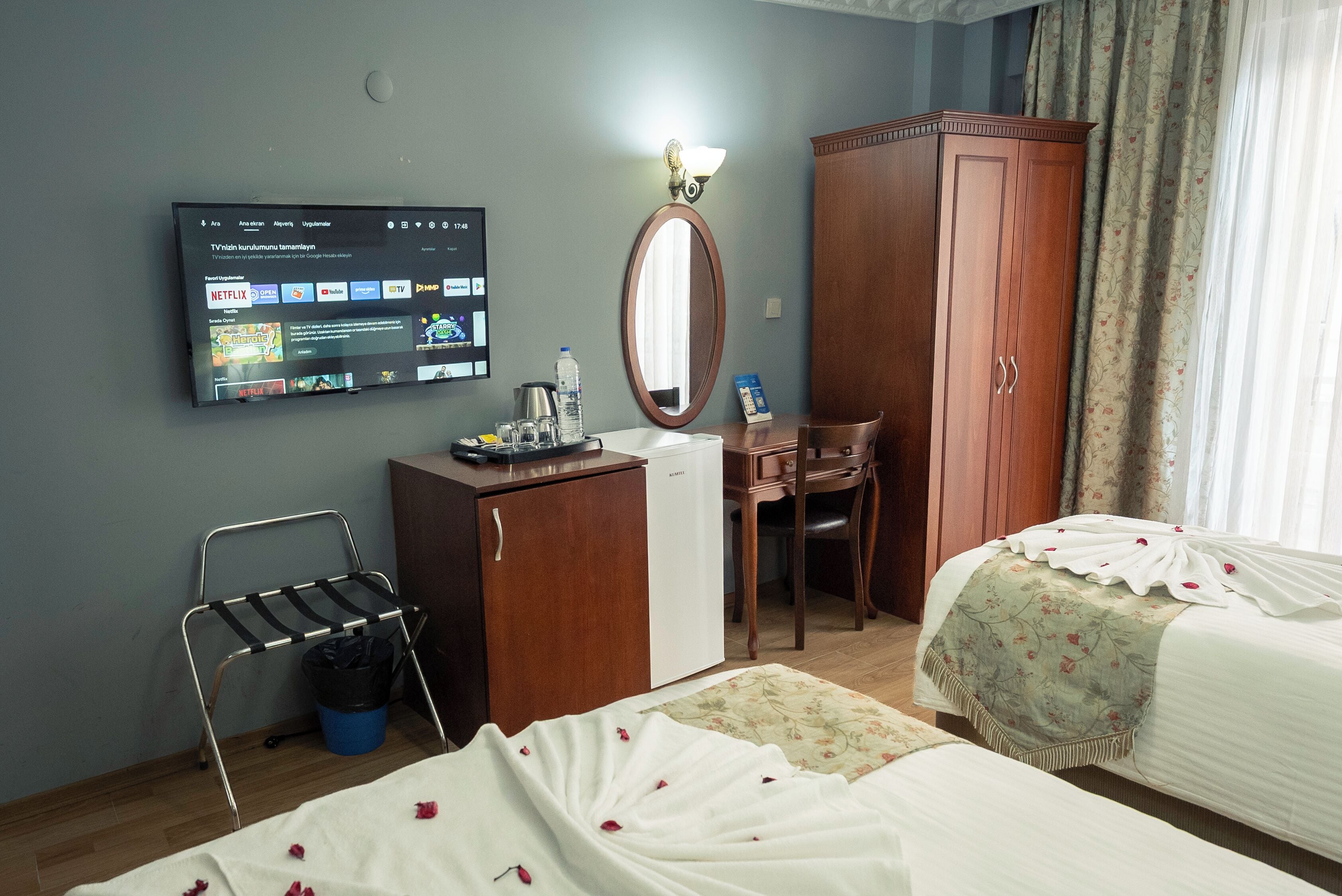 Une chambre d’hôtel comprenant un lit, un bureau, une armoire, un téléviseur diffusant différentes chaînes et une salle de bain.