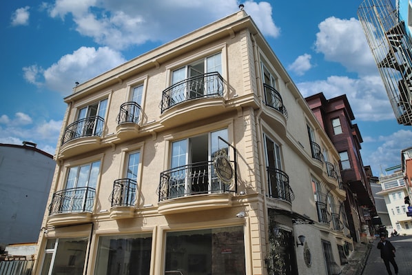 A corner building with multiple balconies, large windows, and a sign indicating it is a hotel. - Basileus Hotel (Istanbul)