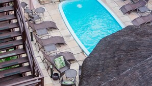 Zona de piscina en la azotea con dos piscinas, sillones de descanso y una escalera.