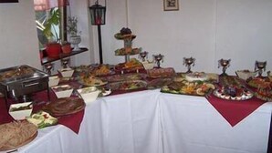 Une table de buffet proposant divers plats et une présentation de fruits.