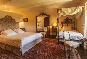 Classic bedroom with two single beds, ornate mirror, and four-poster bed with canopy.