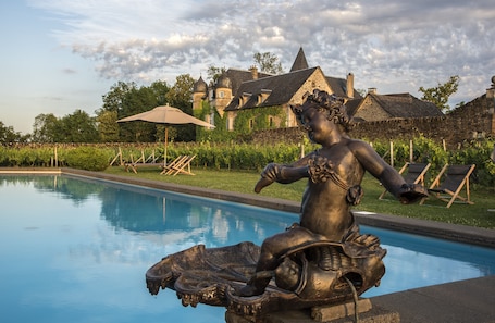 Una piscina al aire libre, tumbonas. Château de Labro