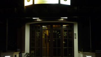 The exterior of the Antik Hotel with illuminated signage and a prominent entrance.