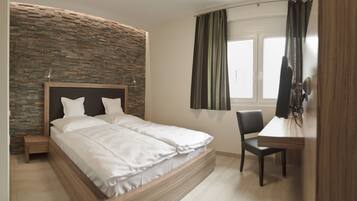 Ein Schlafzimmer mit einem Bett, einem Schreibtisch und einem Stuhl.